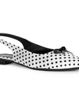 Vista diagonal de flats blanco con lunares negros, suela de piso, pulsera ajustable y moño decorativo