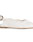 Vista lateral en flats beige con pulsera ajustable, detalle en bordes ondulados y suela de piso para dama 