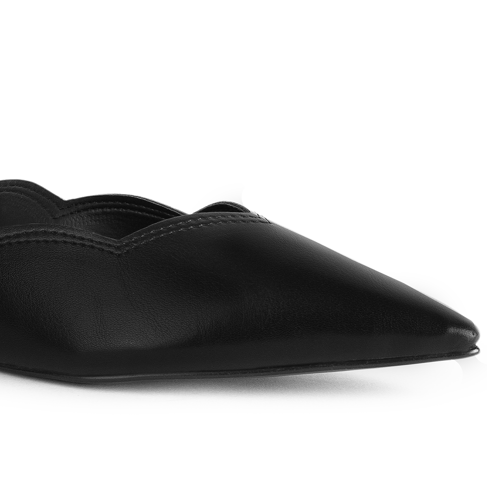 Detalle del material sintético en flats negro para dama con punta fina y bordes ondulados 