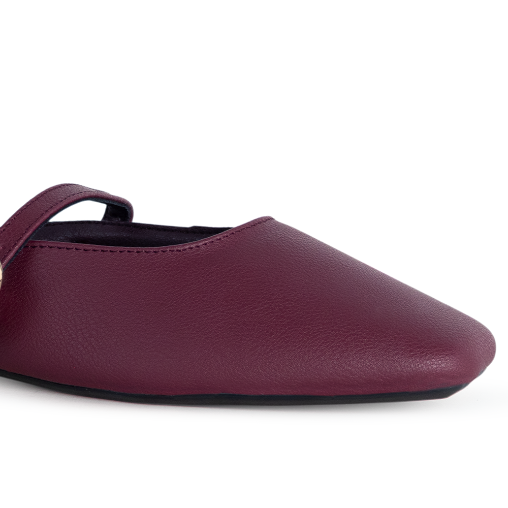 Detalle del material sintético en balerina vino tipo mule para dama con punta semicuadrada de piso y pulsera ajustable en el empeine 