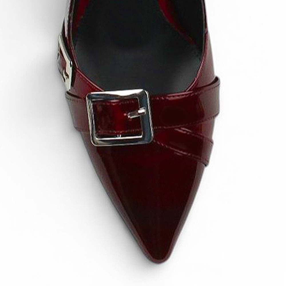 Vista del detalle en punta fina con detalles metálicos de la zapatilla vino de charol con tacón medio 7 cm para dama 