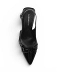 Vista superior de zapatilla negra con punta fina, herrajes metálicos, pulsera ajustable y tacón medio 7cm 