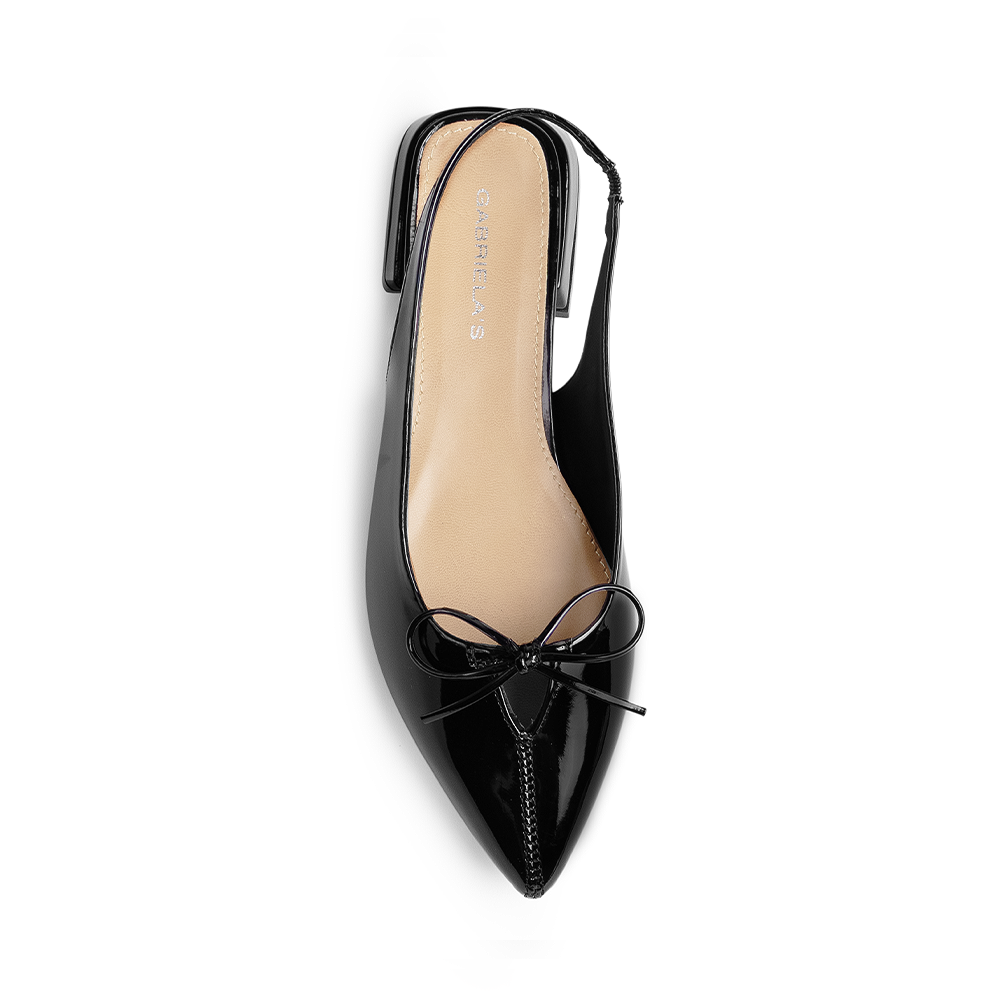 Vista superior en la zapatilla negra con punta fina para dama y moño decorativo en el empeine de talón descubierto 