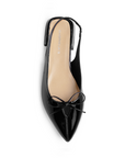 Vista superior en la zapatilla negra con punta fina para dama y moño decorativo en el empeine de talón descubierto 