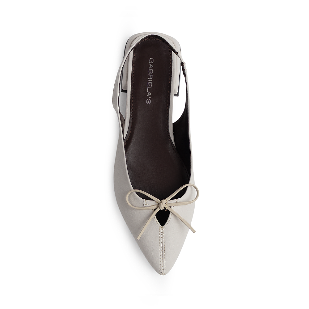 Vista superior en la zapatilla beige con punta fina para dama y moño decorativo en el empeine de talón 