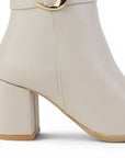 vista trasera del tacón medio 7cm en botas beige de dama 