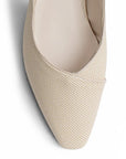 vista del detalle en punta estilizada de la zapatillas beige de dama con tacón  