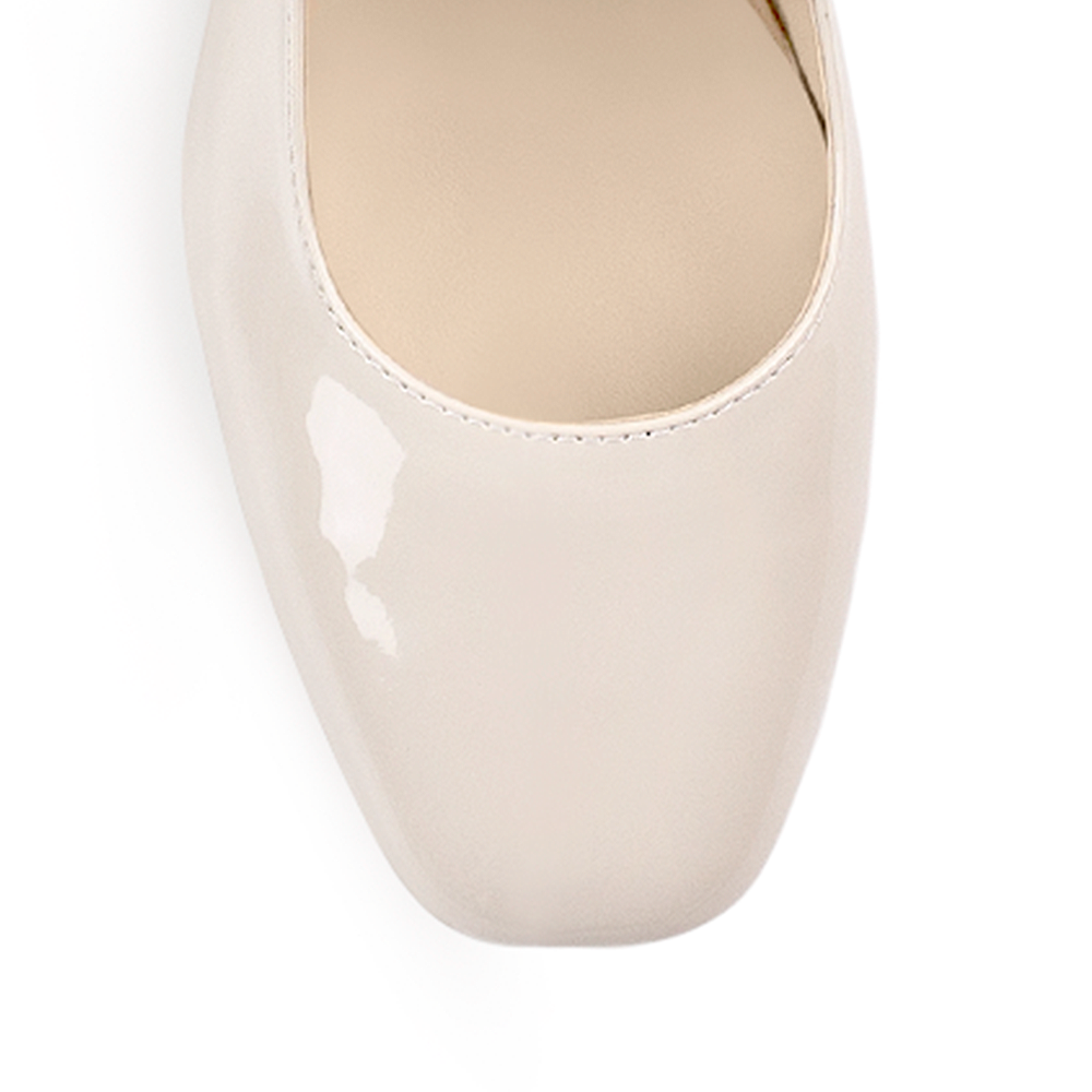 Vista de material charol en zapatilla beige para mujer con tacón bajo de 5cm