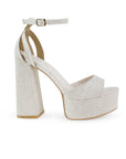 Vista lateral de zapatilla beige en acabado grabado para mujer con pulsera y tacón alto 13cm