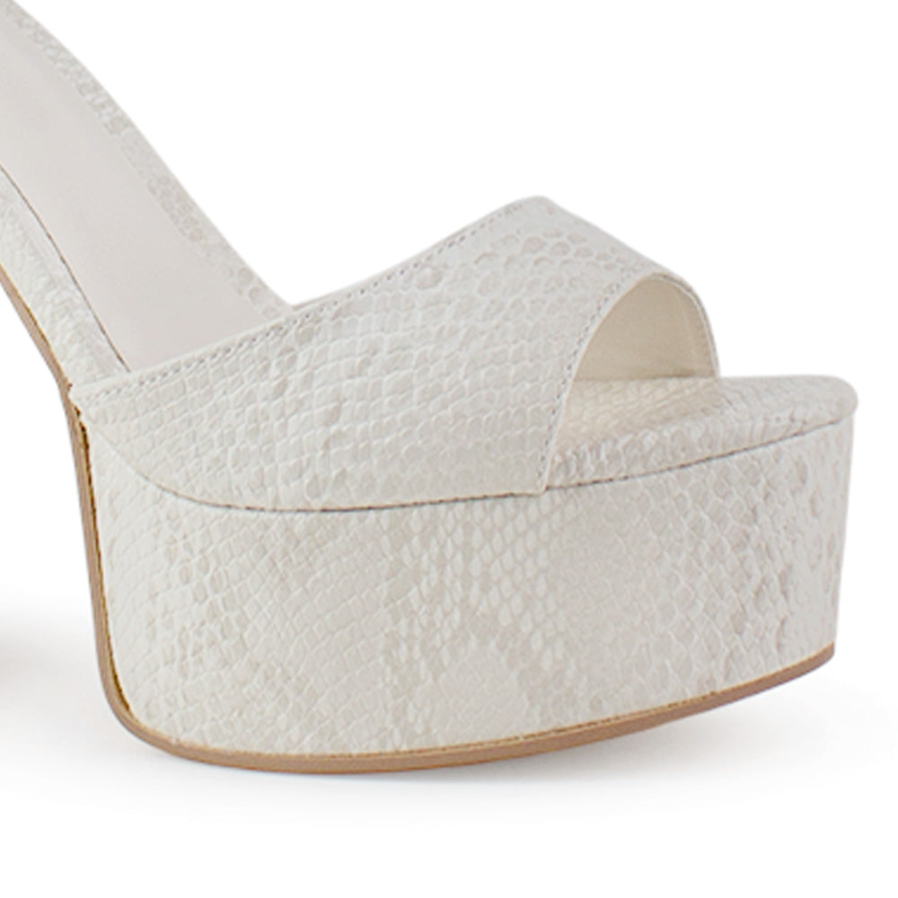 Vista a detalle de zapatilla para mujer con pulsera y tacón alto 13cm en color beige en acabado grabado 