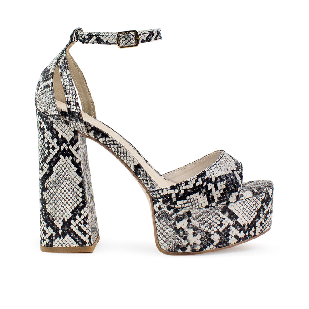Vista lateral de zapatilla beige con negro para mujer con pulsera y tacón alto 13cm