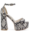 Vista lateral de zapatilla beige con negro para mujer con pulsera y tacón alto 13cm
