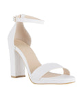 Vista diagonal de zapatilla blanca con tacón tipo bloque de 10cm y pulsera para mujer