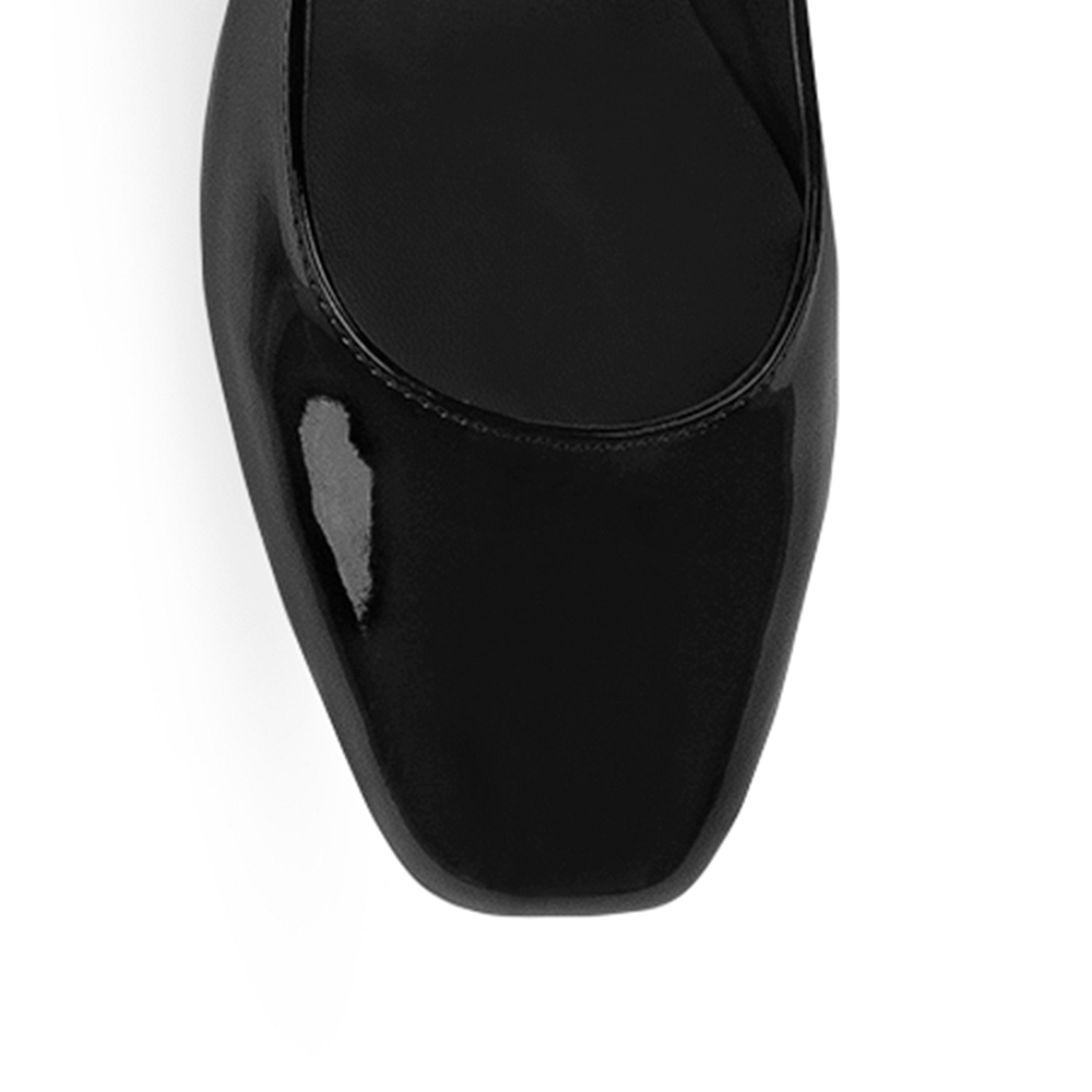 Vista de material charol en zapatilla negra para mujer con tacón bajo de 5cm