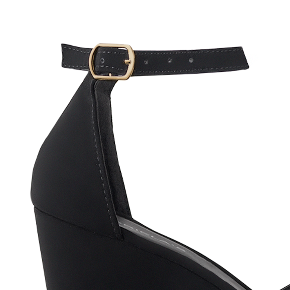 Vista a detalle de zapatilla negra en acabado Buck para mujer con pulsera 