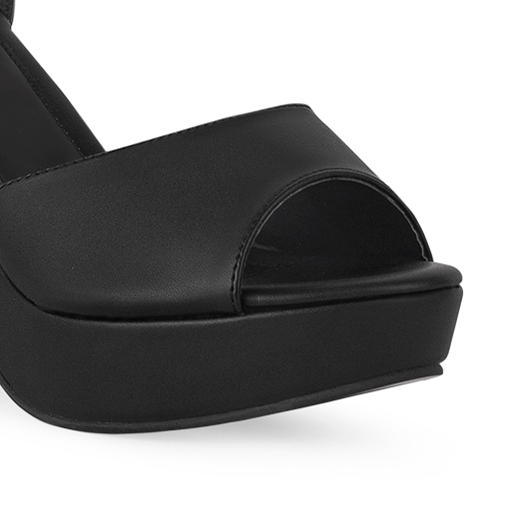 Vista a detalle de zapatilla negra en acabado cabra sintético para mujer con pulsera 