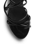 vista del detalle en las tiras cruzadas de las zapatillas negras con tacón  