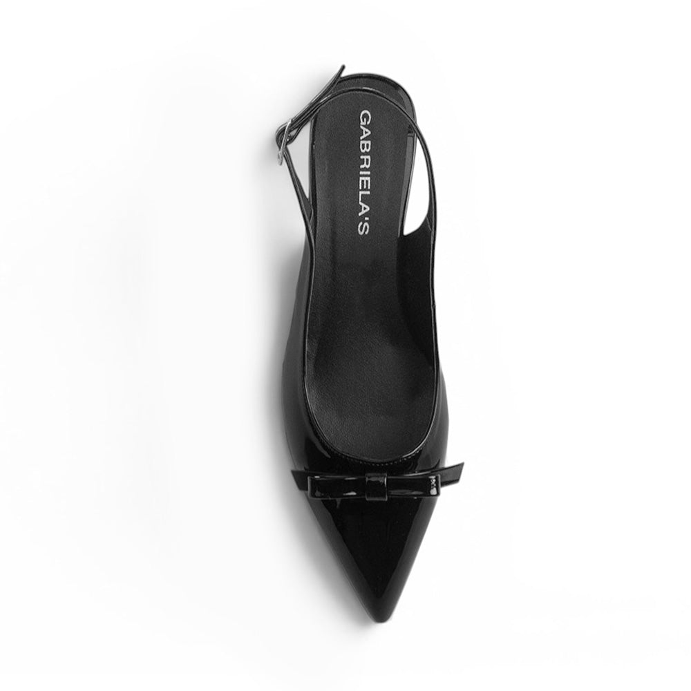 vista superior de zapatillas negras de charol para dama con talón descubierto y terminación en punta