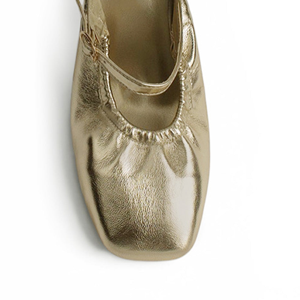 vista del detalle de la pulsera con hebilla dorada en zapatillas para mujer  color oro de tacón 