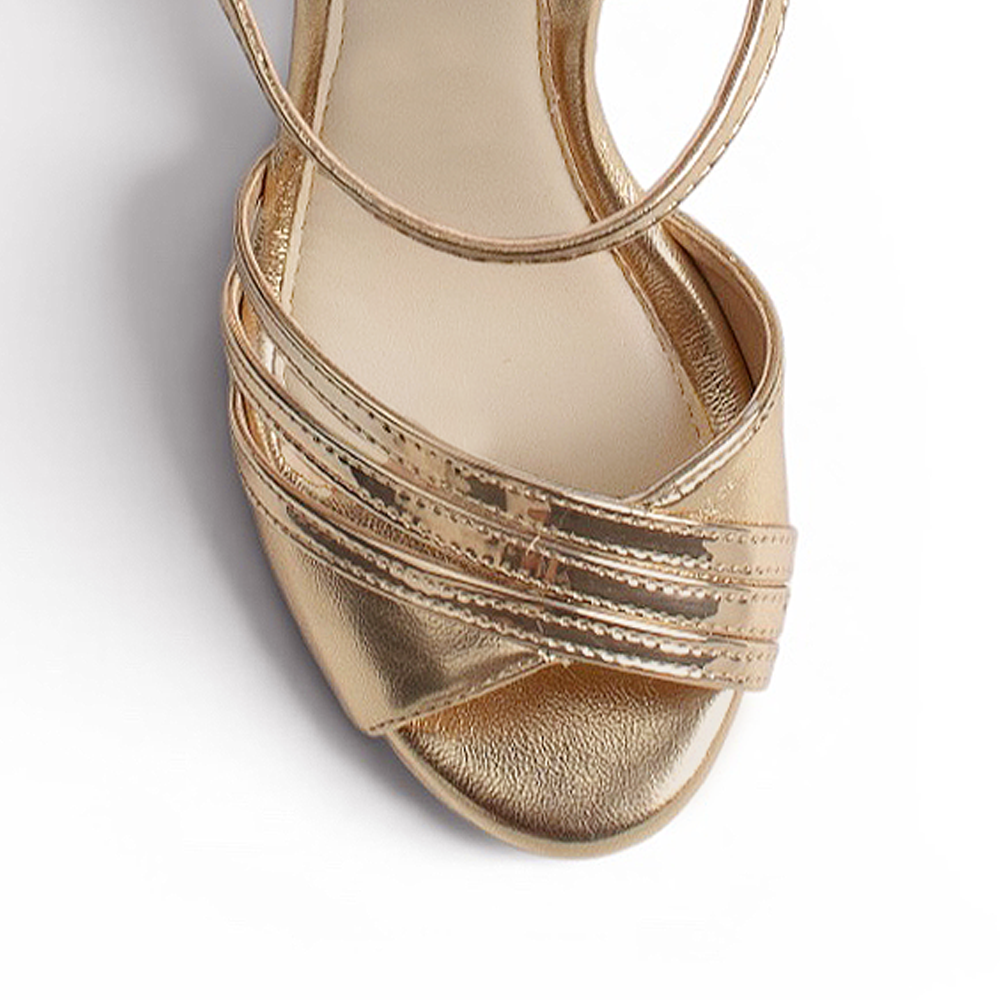 vista del detalle frontal de las zapatillas oro con pulsera y plataforma de dama