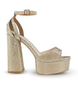 Vista lateral de zapatilla oro para mujer con pulsera y tacón alto 13cm