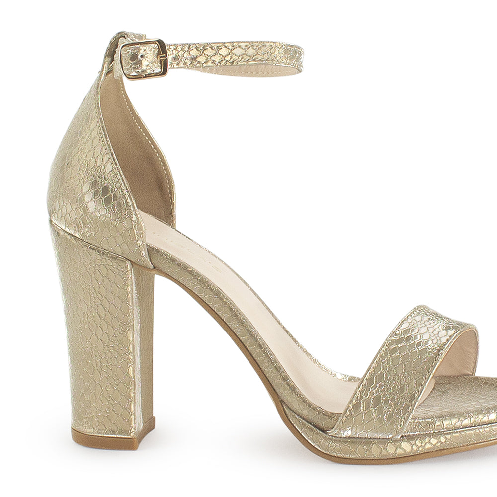 Vista trasera de zapatilla para mujer color oro con pulsera y tacón medio de 10cm