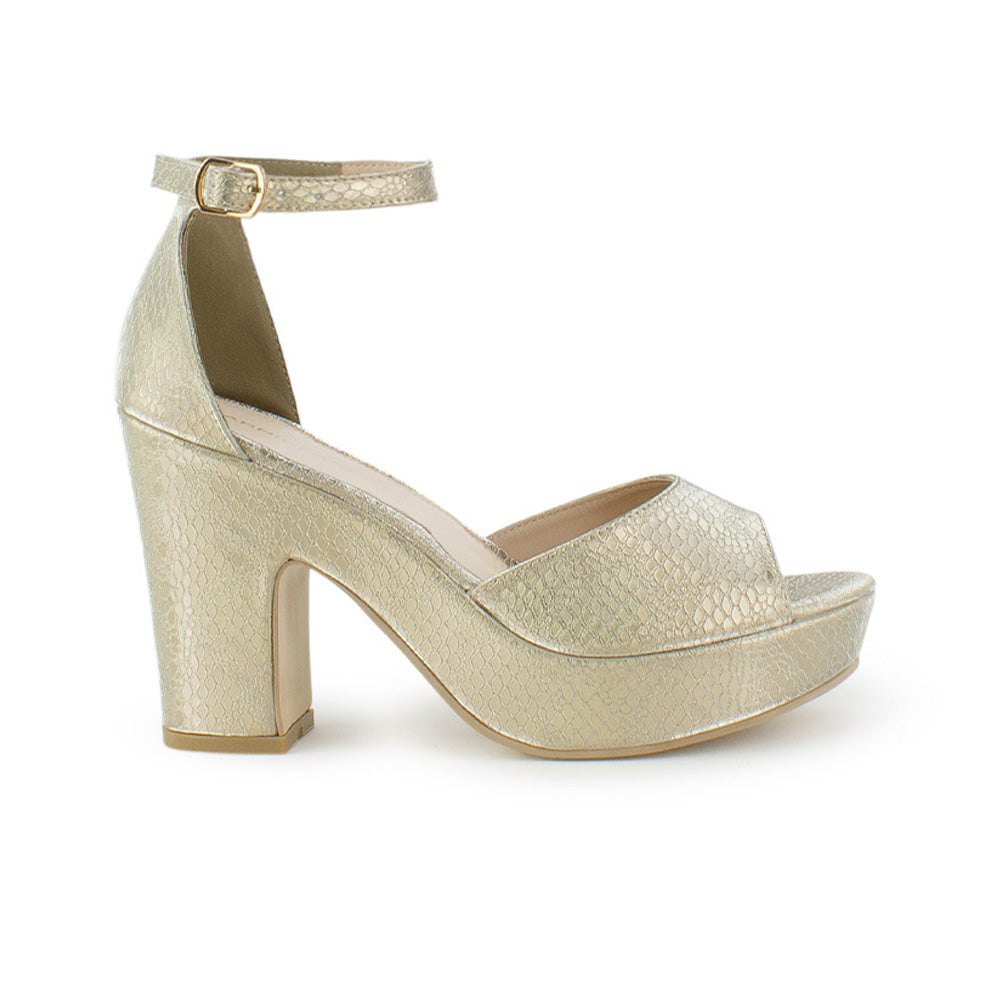Vista lateral de zapatilla para mujer en color oro con pulsera y tacón ancho de 10cm