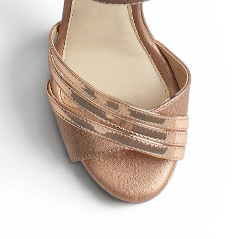 vista del detalle frontal de las zapatillas oro rosa con pulsera y plataforma de dama