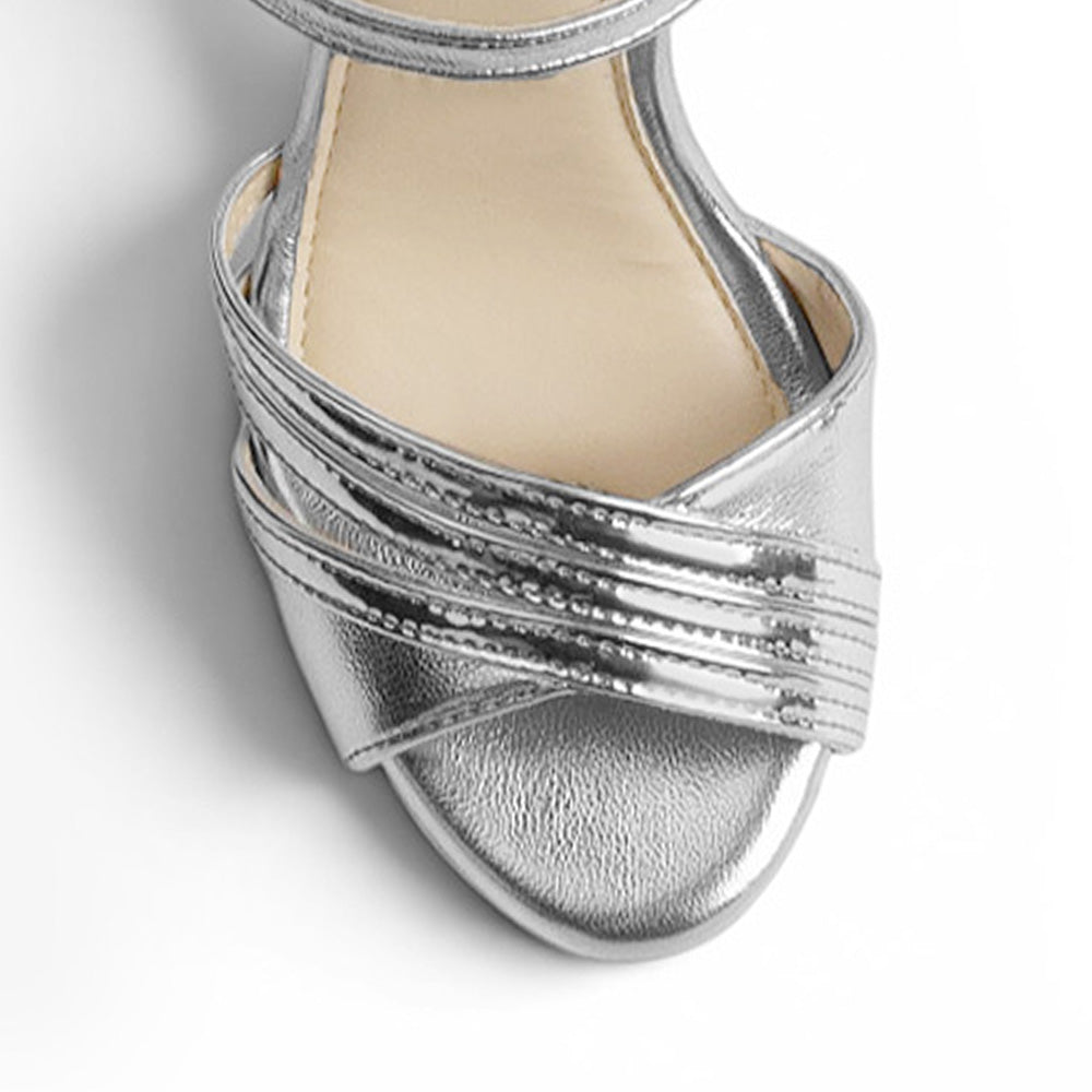 vista del detalle frontal de las zapatillas plata con pulsera y plataforma de dama