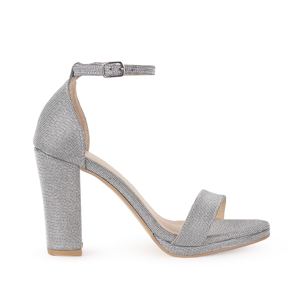 Vista lateral de zapatilla plata en acabado brilloso con pulsera y tacón medio de 10cm para mujer