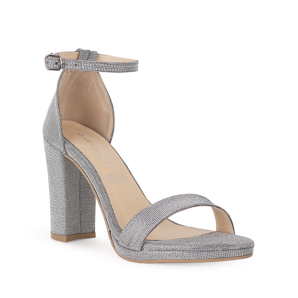 Vista diagonal de zapatilla plata en acabado brilloso con tacón tipo bloque de 10cm y pulsera para mujer