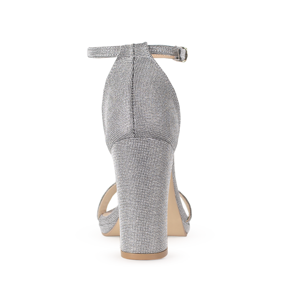 Vista trasera de zapatilla para mujer color plata acabado brilloso con pulsera y tacón medio de 10cm