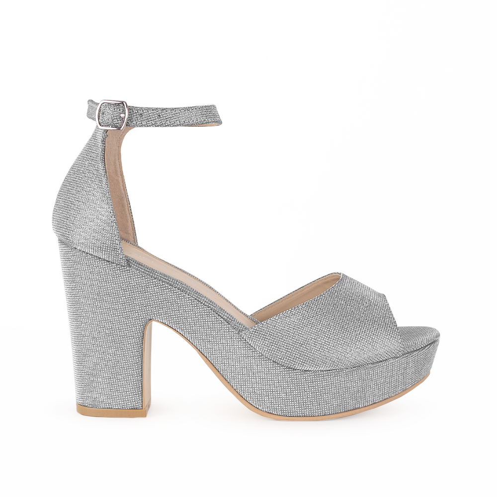 Vista lateral de zapatilla para mujer en color plata brilloso con pulsera y tacón ancho de 10cm