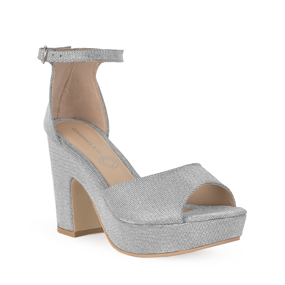 Vista diagonal de zapatilla para mujer con pulsera y tacón ancho en color plata brilloso 