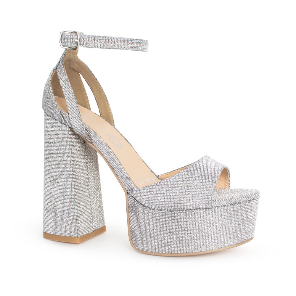 Vista diagonal de zapatilla para mujer con pulsera y tacón alto 13cm en color plata brilloso