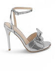 vista lateral de zapatilla plata de mujer con moño y tacon delgado