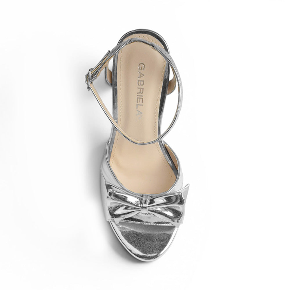 vista superior de zapatilla plata de mujer con moño y tacon 