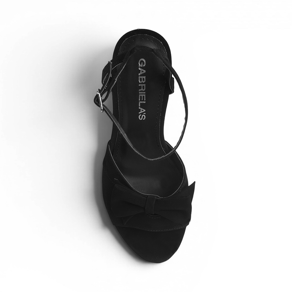vista superior de zapatilla negra de mujer con moño y pulsera 