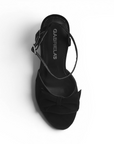 vista superior de zapatilla negra de mujer con moño y pulsera 