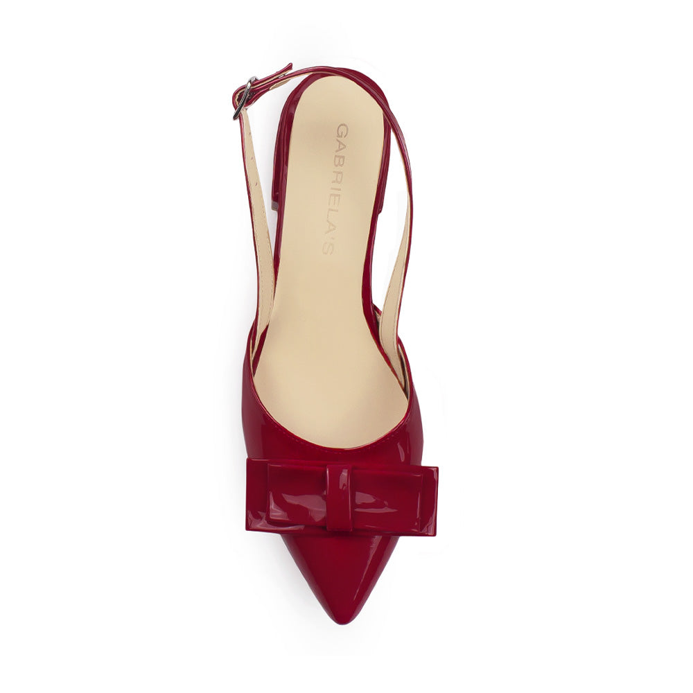 Vista superior de zapatilla roja puntal para mujer con moño 
