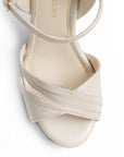 vista del detalle en tiras cruzadas del frente en zapatillas beige de mujer con plataforma 