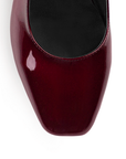 Vista de material charol en zapatilla vino para mujer con tacón bajo de 5cm
