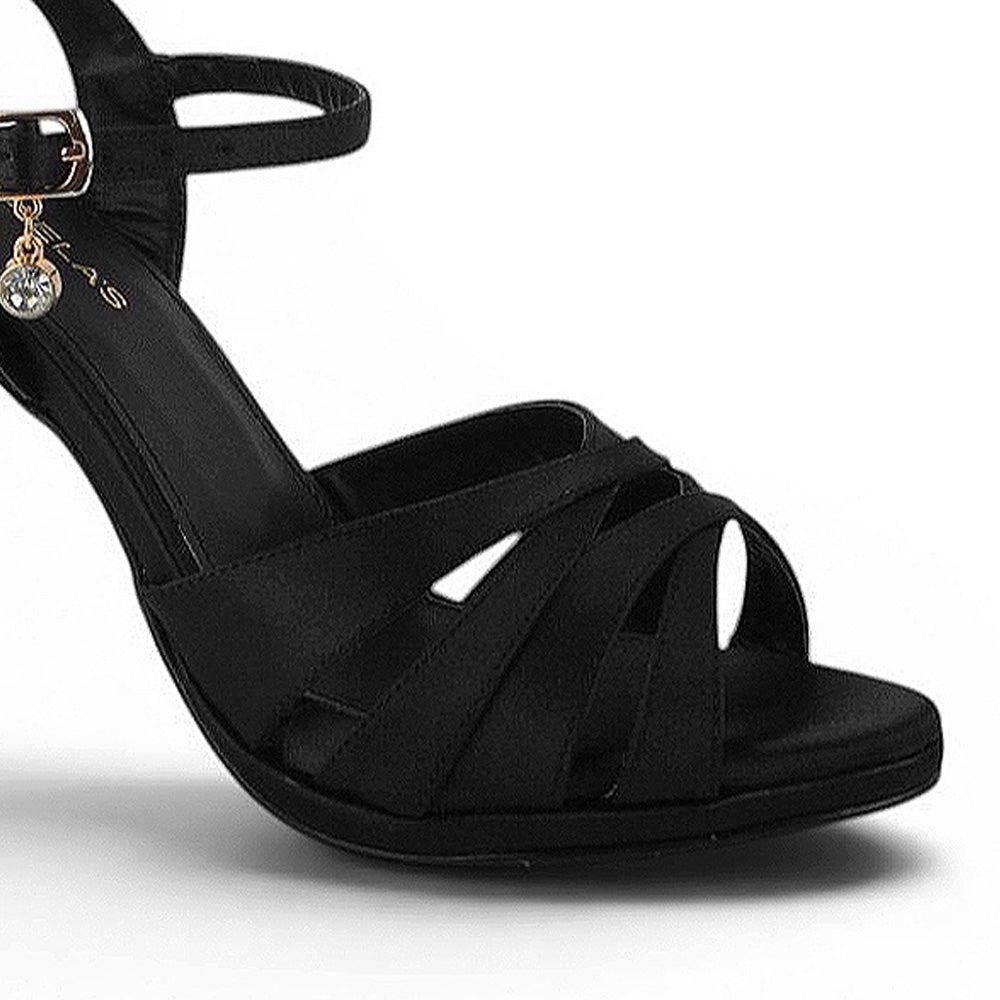 Detalle de material shantung en zapatillas negras con tacón y tiras 